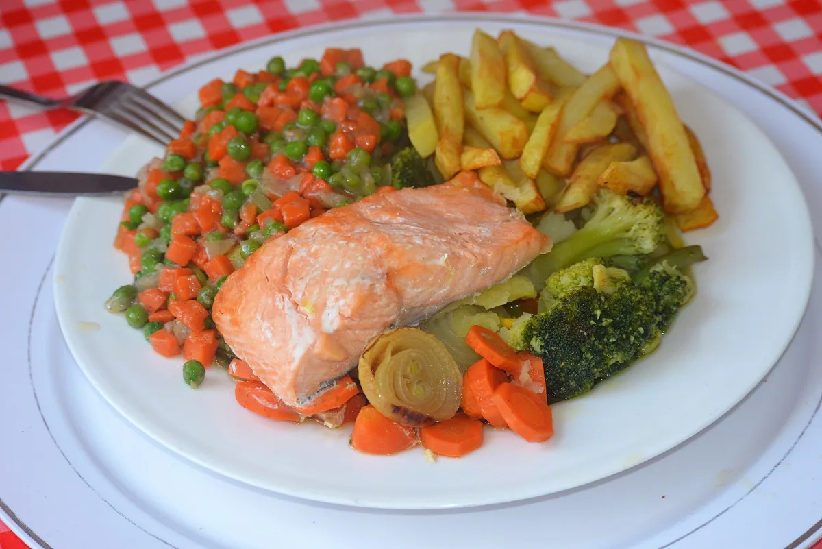 Prato de filé de salmão com legumes, brócolis e batatas fritas, refeição de peixe típica da sexta-feira