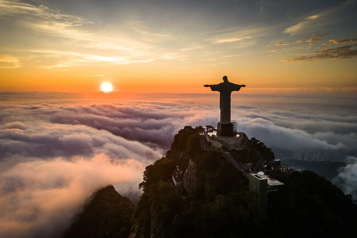 Cristo Redentor sobre o Corcovado acima das nuvens ao amanhecer