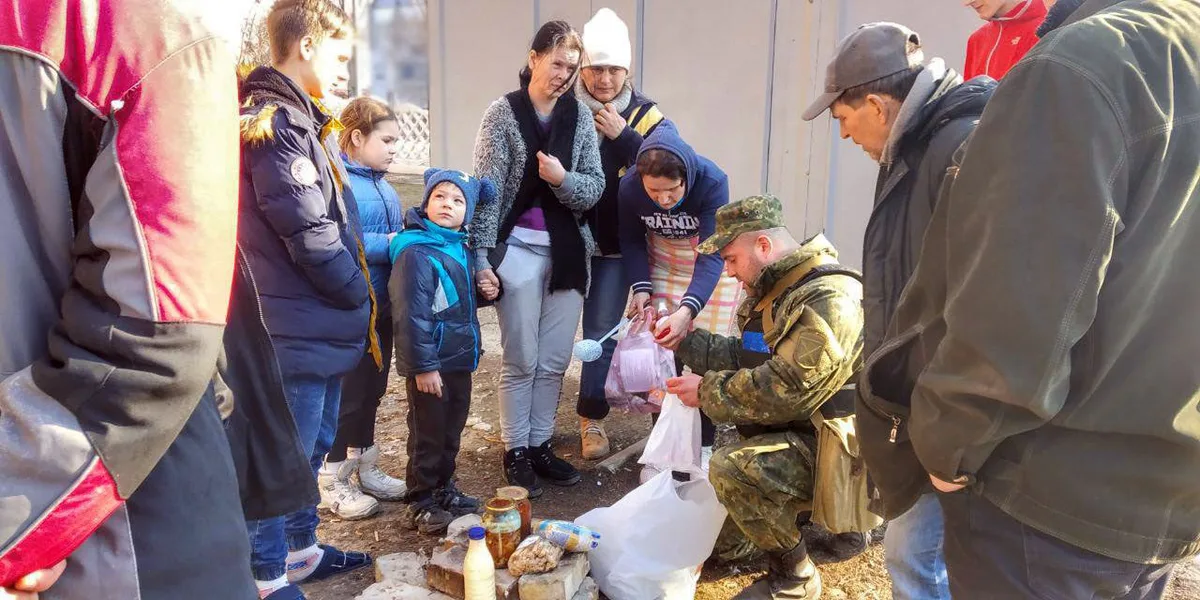 Policial ucraniano distribui alimentos e ajuda humanitária a moradores e crianças em Maryinka, Ucrânia