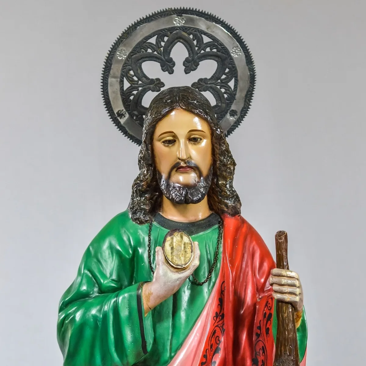 Imagem de São Judas Tadeu com auréola, medalhão e bastão, em manto verde e vermelho