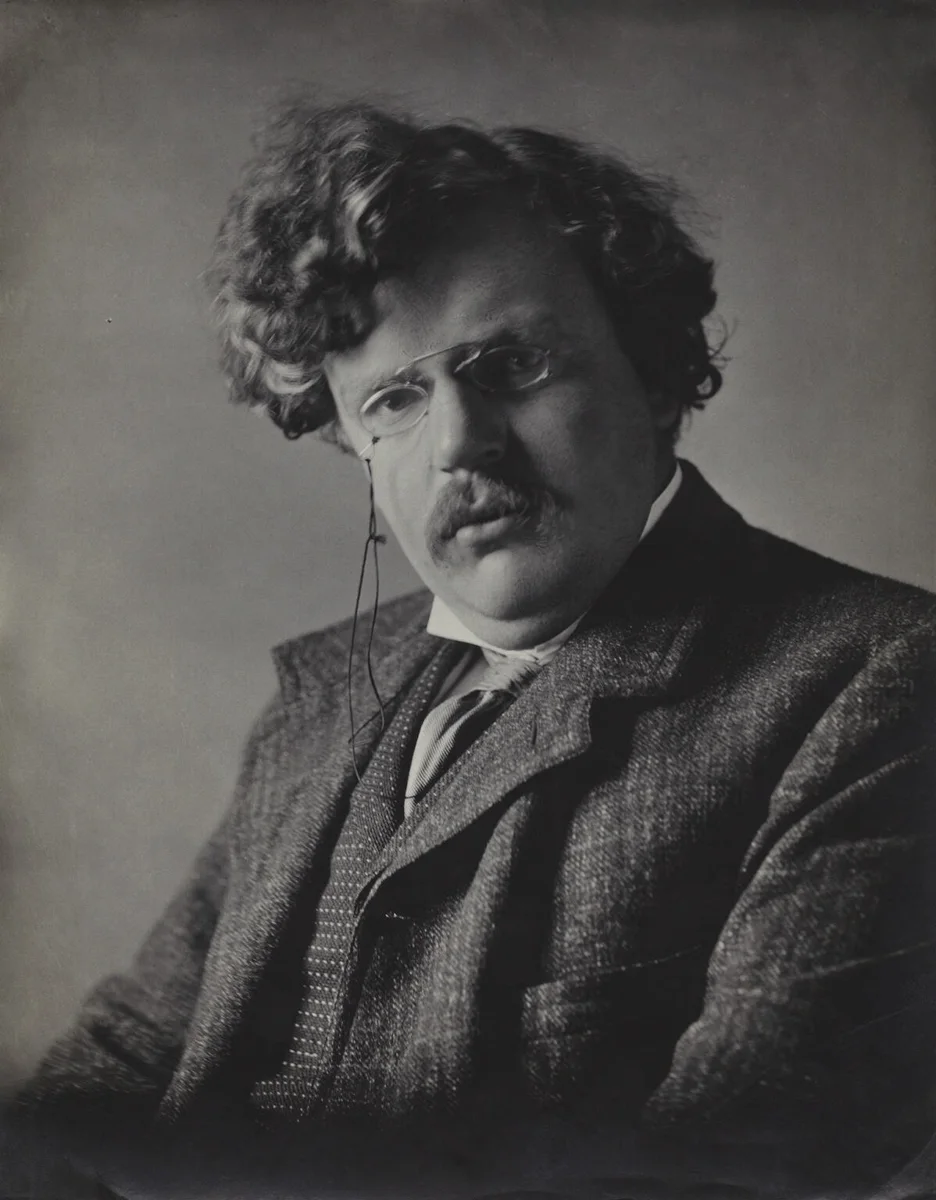 Fotografia de G. K. Chesterton em 1909, de terno, com bigode e cabelos ondulados